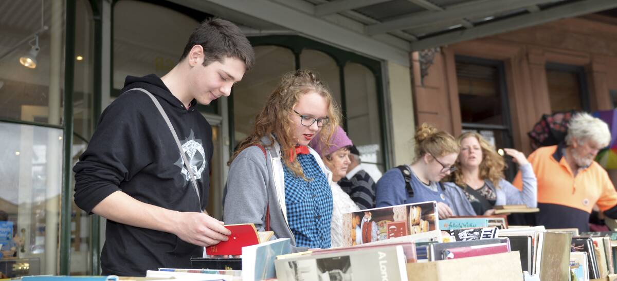Fossicking: Literature-lovers trawl through boxes of bargain books to find what kind of gems the Clunes Booktown festival has to offer. Picture: Dylan Burns