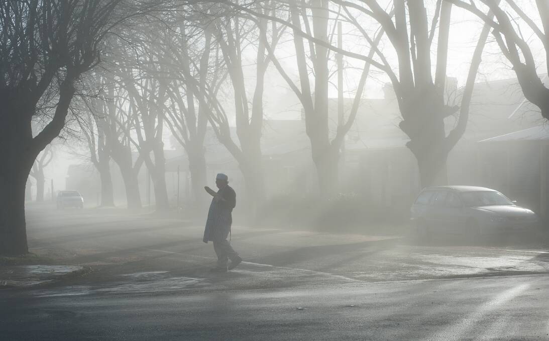 Blissful mornings: Juan Guzman from Trentham Bakery navigates the township's misty main street, baguette in hand. Weather forecasts for Hepburn Shire predict a wet but warm winter. Picture: Sandy Scheltema