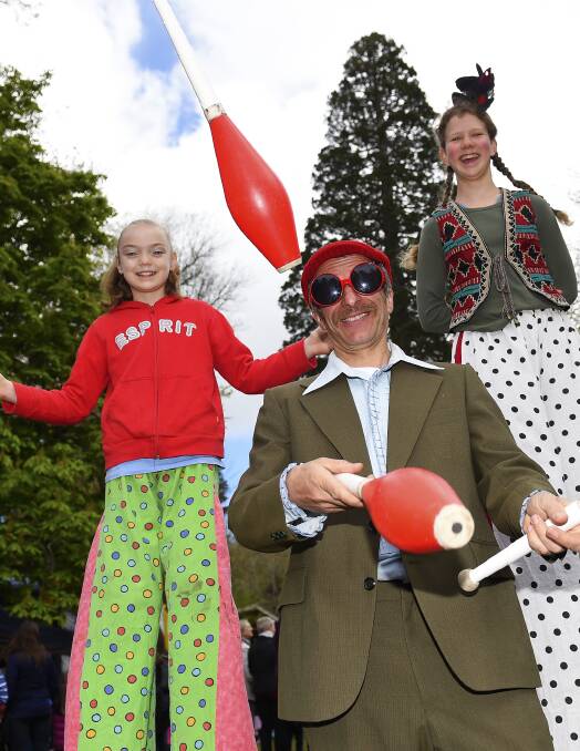 HIGHS AND LOWS: Juggling at the festa was Eric Jarlaud, while Leni Newton, 10, and Ella Saabel, 13, were walking tall. 