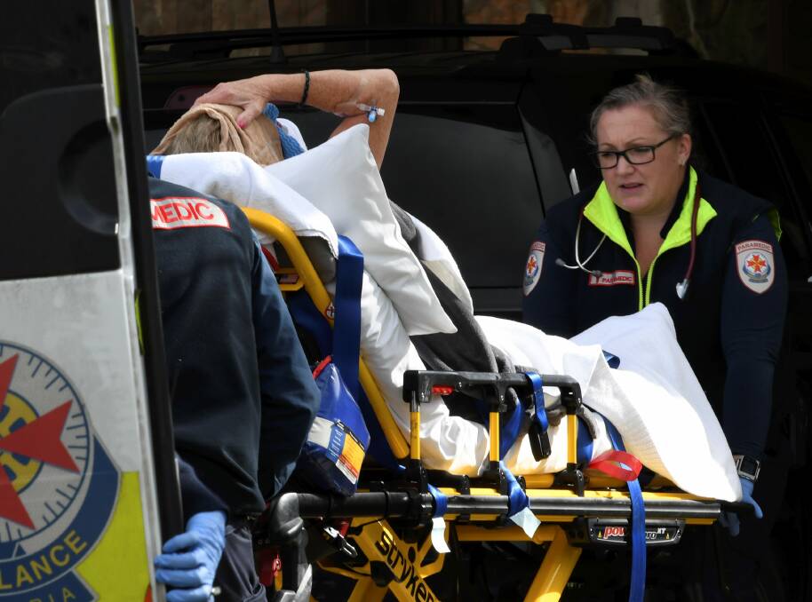 INJURED: A woman is taken on a stretcher to hospital after being burnt.