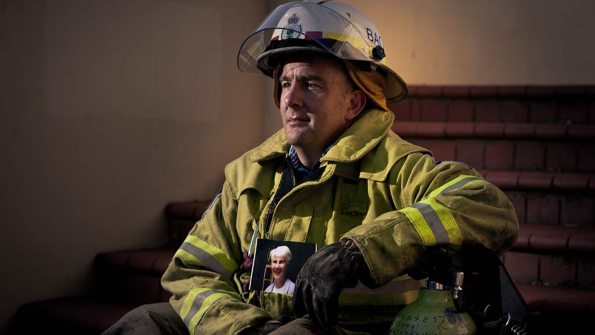 Volunteer RFS firefighter Ian Turnbull holds a photo of his mother, who died from motor neurone disease. Picture: Perry Duffin