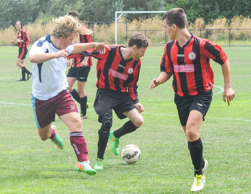 ON THE BALL: Daylesford and Hepburn United's Seb Lukoszek-Every and Ivan Carter take on a Creswick player in the division one section at the weekend.