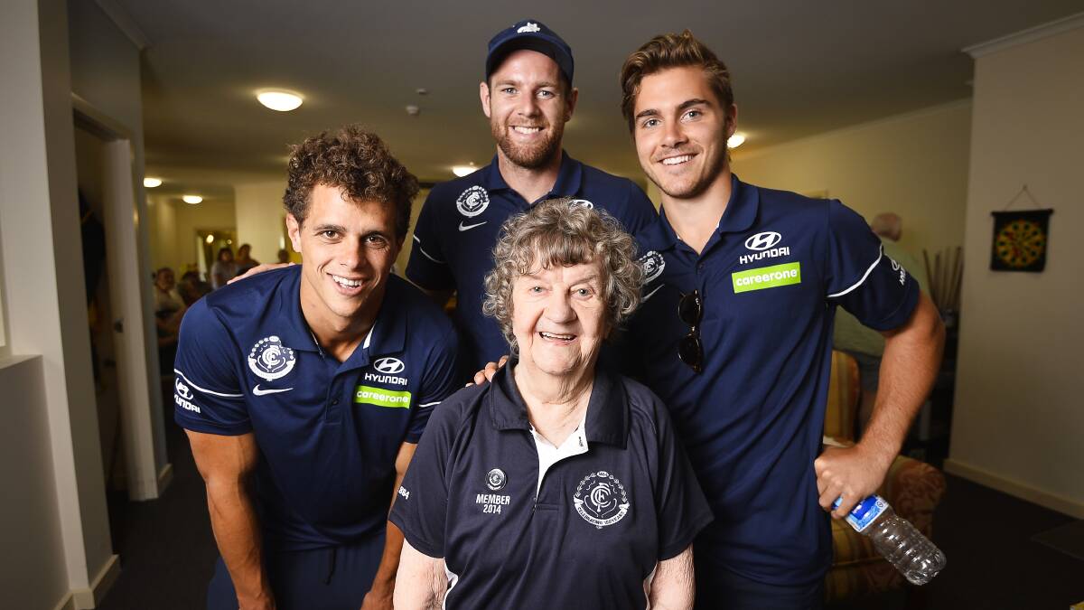 Over the moon: Hepburn House resident Beth Thornycroft, 92, with her favourite Carlton players, Ed Curnow (L), Sam Docherty and Cameron Polson (R).  Picture: Dylan Burns. 
