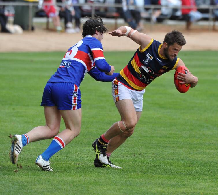 BREAKING CLEAR: Beaufort's Damien Day looks to escape the tackle of Daylesford opponent Cameron Ralph during Saturday's clash that the Crows won convincingly. Picture: Lachlan Bence.