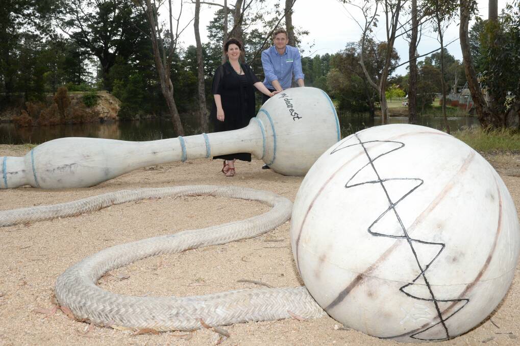 A sculpture known pejoratively as "the wrecking ball" has been installed at Calembeen Park. Hepburn Shire mayor Sebastian Klein and Hepburn Shire's public art panel member Kim Percy stand with the giant cup and ball. Picture: Kate Healy.