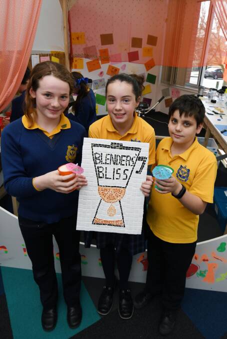 BLENDED: St Columba's Primary School grade five pupils Molly, Stephanie and Sam show off their mosaic logo and smoothies blended by bike in their Blender's Bliss juice bar during their school expo. Picture: Kate Healy