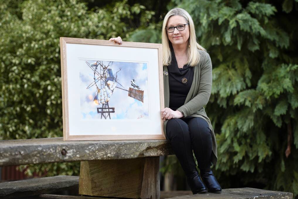 RURAL LOVE: Local artist Helen Cottle poses with a piece from her art series "Rural Love" outside The Cosmopolitan Hotel in Trentham. The exhibition opens at the iconic Trentham hotel on Friday. Picture: Dylan Burns. 