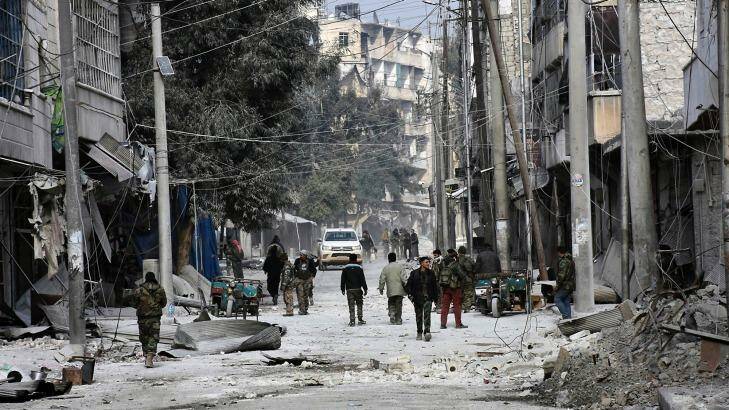 Syrian soldiers and civilians marching through the bomb-damaged streets of east Aleppo. Photo: SANA/AP