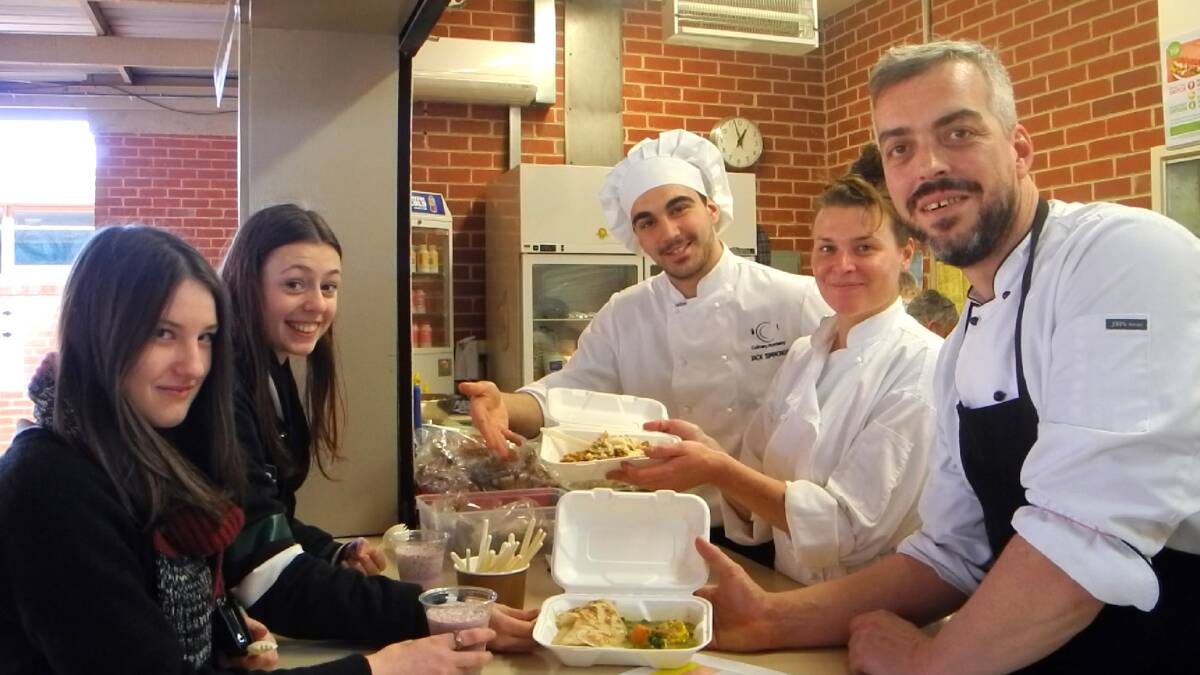 Claire Hartigan (back) and Ashleigh Nolan, year 12, get served some healthy food from apprentice Jack Simmonds and chefs Kylie Himmerman and Christian Reuther. Picture: EMMA-JAYNE SCHENK 