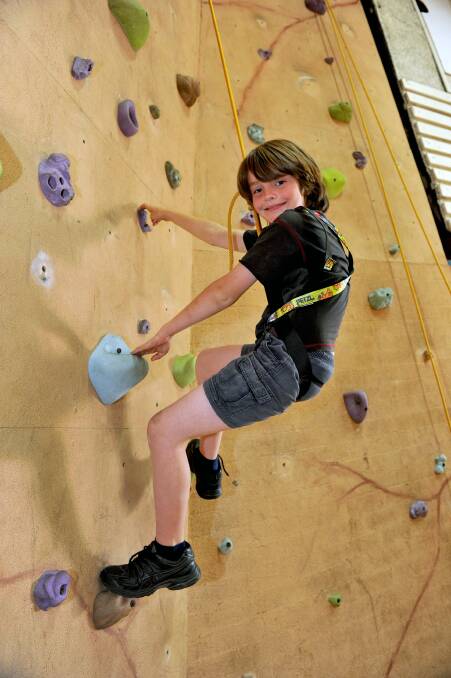Max Burder has a go on the climbing wall. Picture: JULIE HOUGH