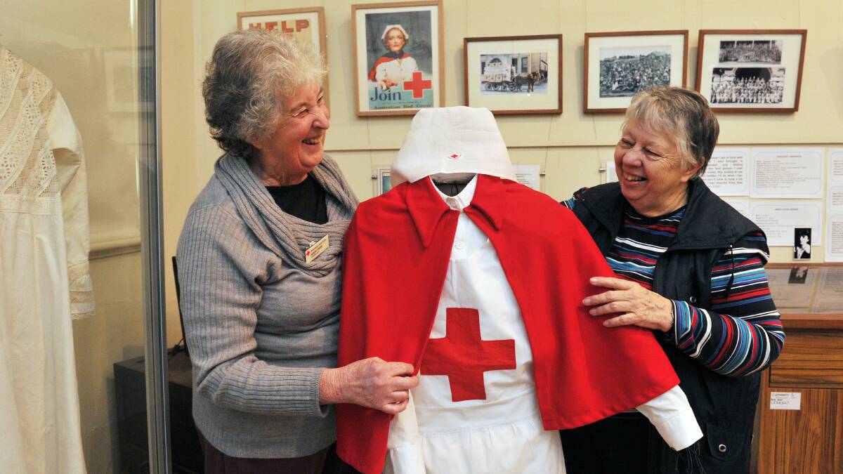 RED CROSS: The Creswick Museum is currently exhibiting Red Cross memorabilia to commemorate 100 years of Red Cross. Pictured are Norah Stubbs, Creswick Red Cross branch secretary, and Margaret Fullwood, Museum Curator. Picture: JULIE HOUGH.