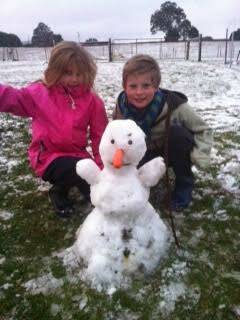 Lila and Jonas build a snowman in freezing conditions at Lyonville