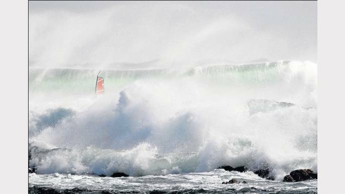 TASMANIA: A Red Bull Storm Chaser’s windsurfer is dwarfed by waves during a leg of the challenge.