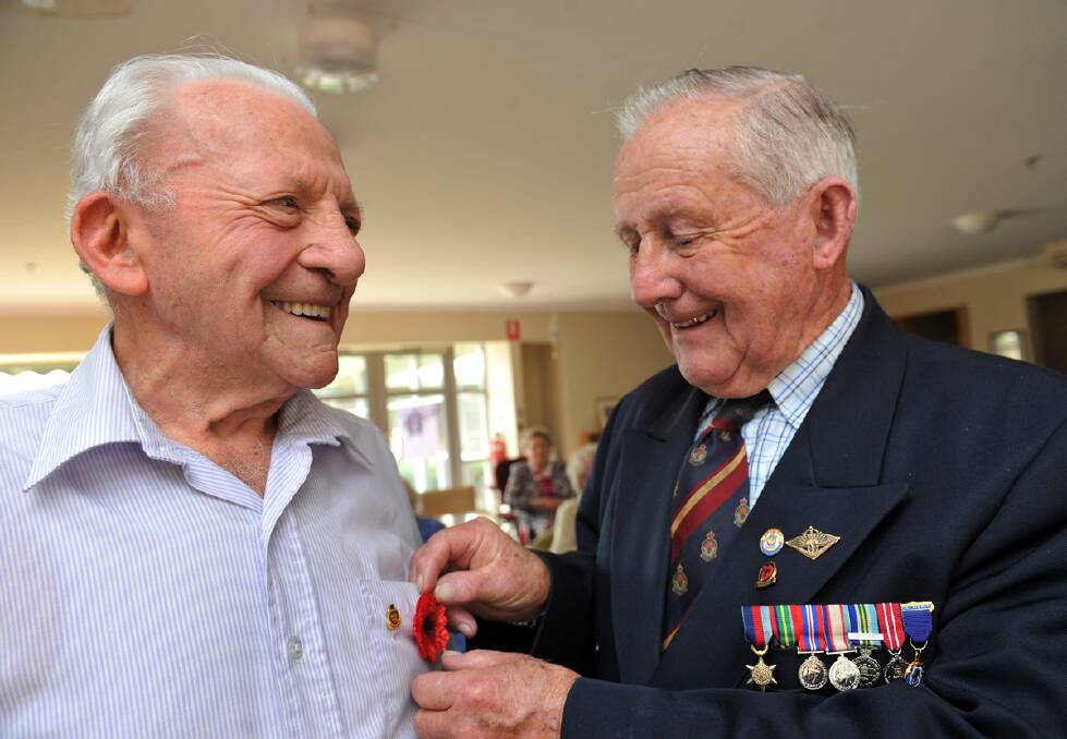 Remembrance Day Service at Trentham Aged Care Facility,veteran Jack Willmott pins a popy on fellow veteran Stuart Reed. : JULIE HOUGH