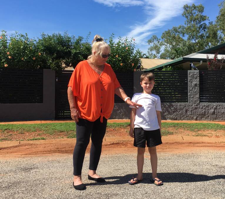 Sue Moran shows how high the floodwater would have reached in front of her house on her grandson Cooper. Picture: Tom Robinson. 