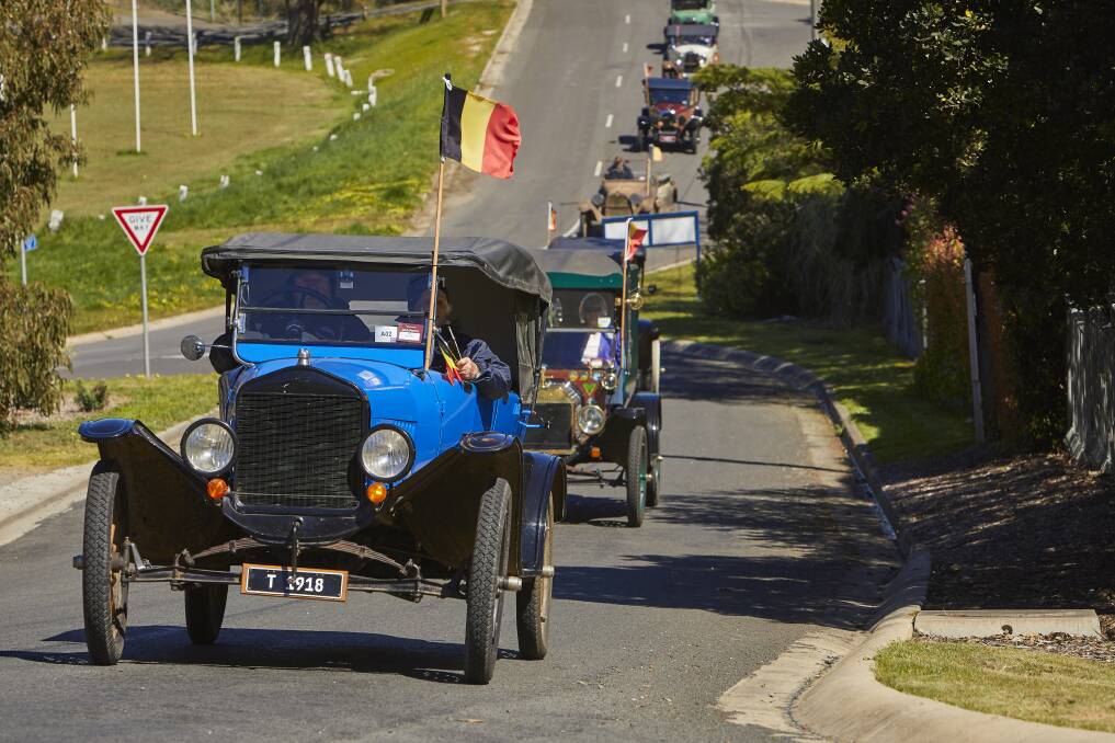 CONVOY: A vintage car leads Maryborough District Historic Vehicle Club members into Creswick on Saturday. Pictures: Luka Kauzlaric