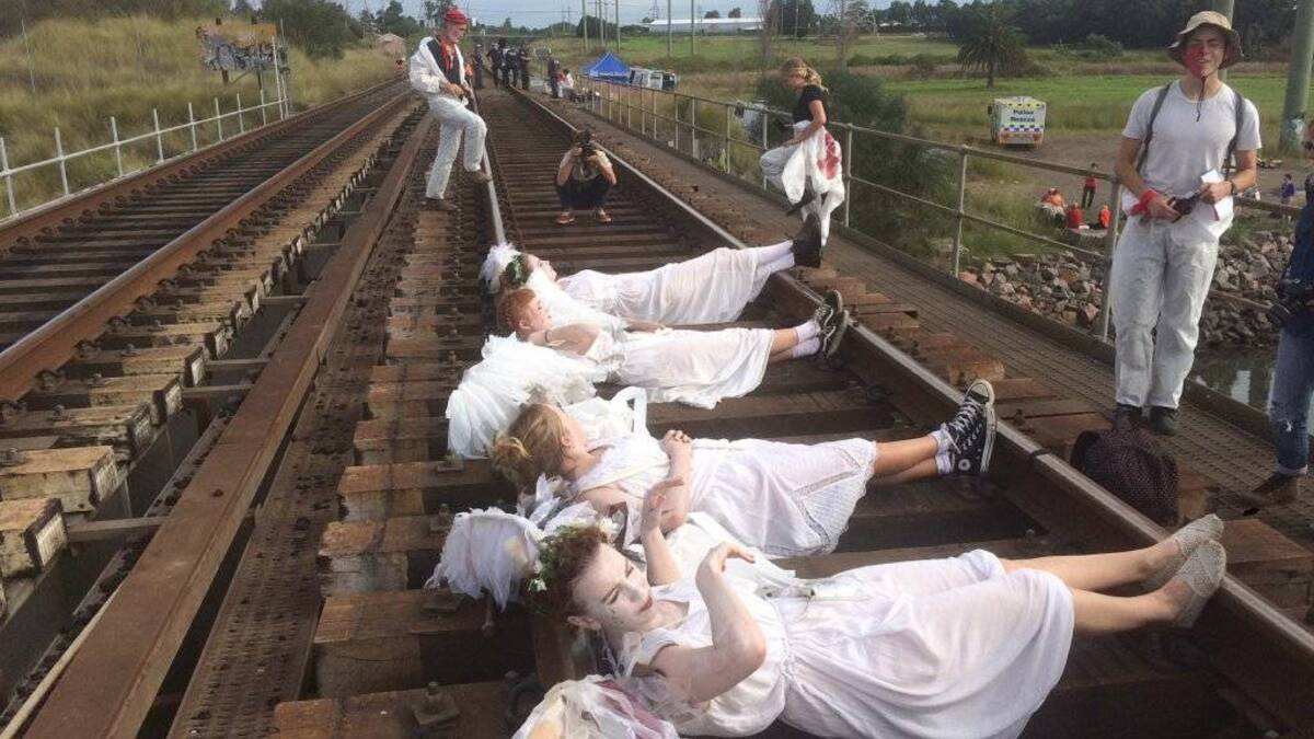 Divine intervention: Anti-coal protesters dressed as angels lay on the tracks to coal prevent trains entering Kooragang Island in April 2016. Picture: @FossilFuelsMU