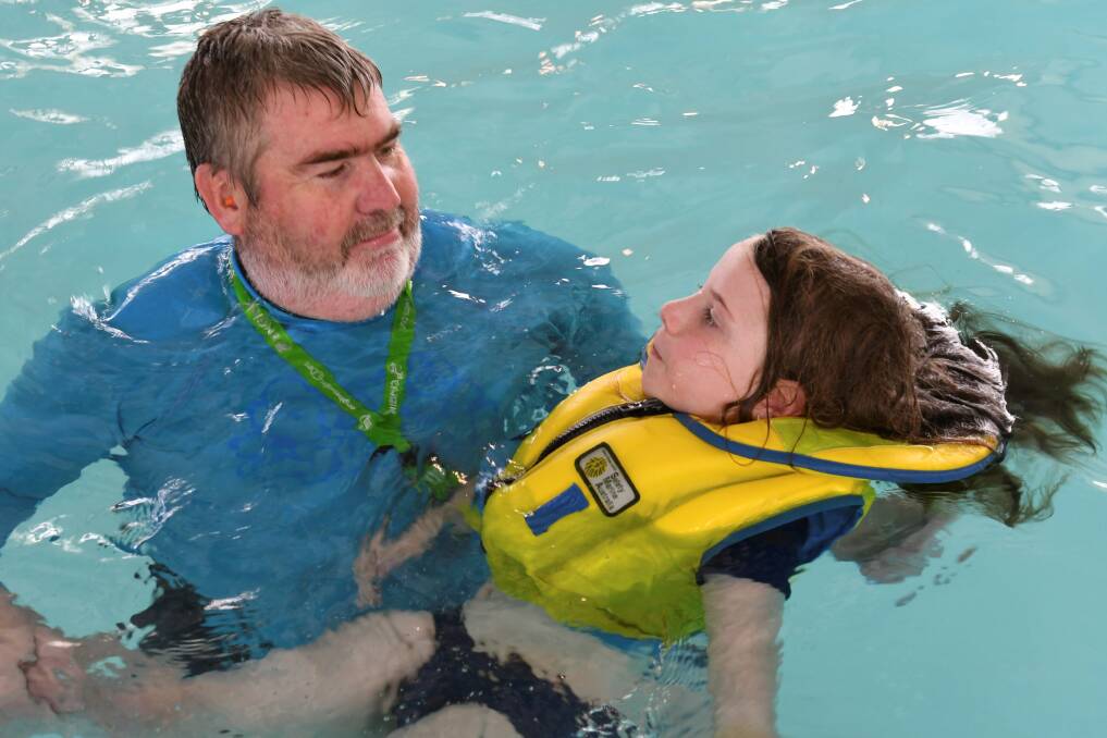 AWARE: Instructor Bill Reddick helps Clunes pupil Amelia learn open-water safety techniques in a simulated program at Ballarat Aquatic and Lifestyle Centre for Water Safety Week. Picture: Lachlan Bence