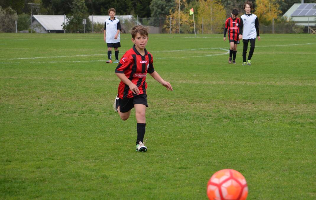 ACTION: Daylesford under-13 player Logan Koleski on the chase against North Ballarat. Picture: Josh Smith