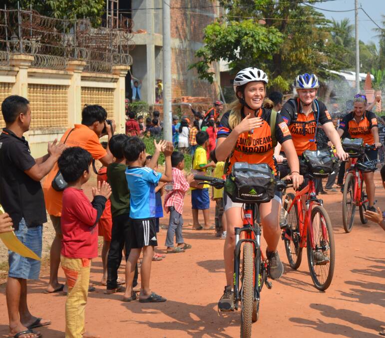 EMOTION: Cyclists finish in the Siem Reap school, which their efforts on the 650-kilometre journey support. Picture: Feeding Dreams Cambodia