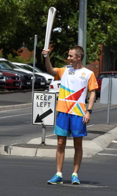 HITTING THE ROAD: Newlyn-raised Jared Tallent proudly holds up the 2018 Commonwealth games baton carrying the Queen's message. Picture: Lachlan Bence