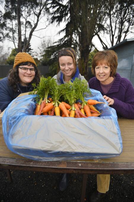 Assisting the build: Hepburn Food Hub volunteers Laura Mitchell and Glenda Holmes with Hepburn Wind manager Taryn Lane after Hepburn Wind made a donation to fit out a shed.  Picture: Dylan Burns.  