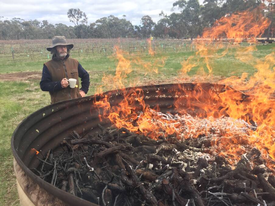 Well earned: Martin Wynne enjoys a cuppa as the last of the vines pyrolyse. Picture: Caleb Cluff.