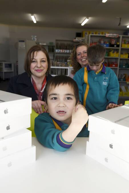 A voice: State Schools' Relief CEO Sue Karzis, Specialist School speech pathologist Els Tielemans, students Elijah, 8 and Charles, 5, with new iPads. Picture: Lachlan Bence.