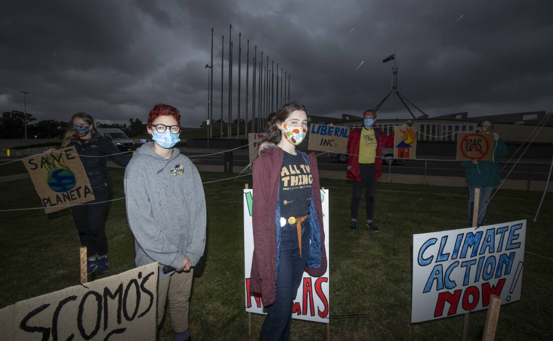 Jimmy Hollo and Rosie Brady joined over 70 ACT students on the lawns of Parliament House on Friday to demand action on climate change. Picture: Sitthixay Ditthavong 