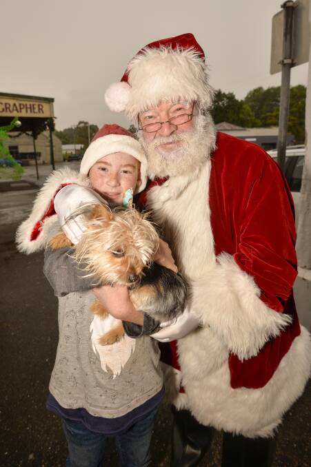 CELEBRATION: James de Kort, 10, who created the doggy gifts, with his pooch Pebbles and Santa Claus. Photo: Dylan Burns