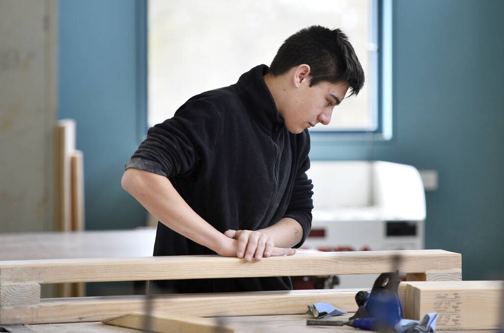 TRADE: Year 10 student Josh Barry sanding down his project in the wood work room. Photo: Dylan Burns