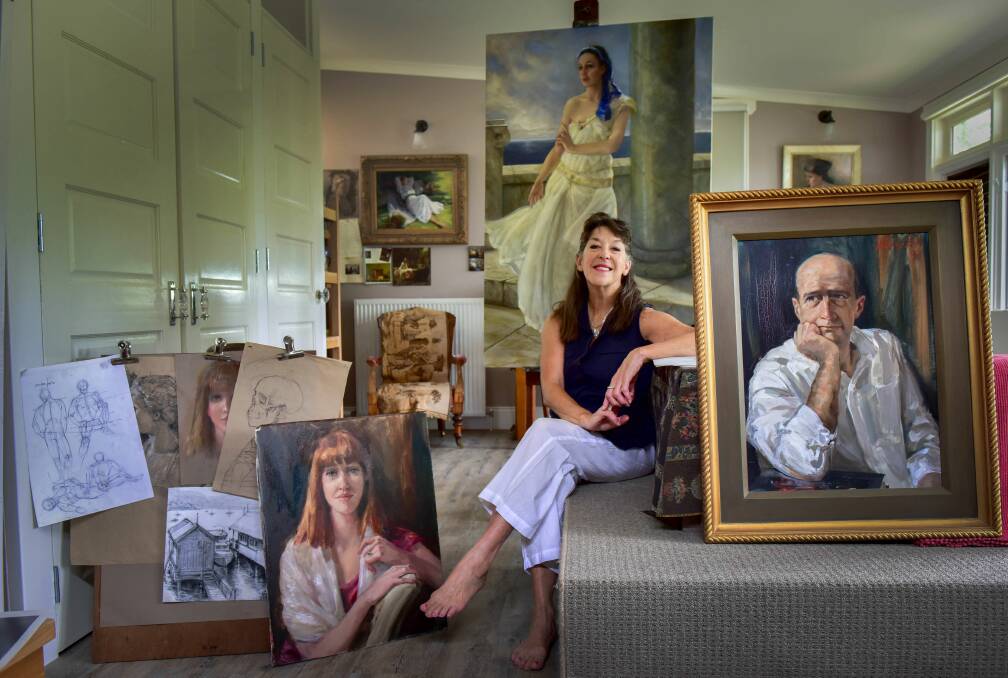 AMONG FRIENDS: Artist Deny Christian in her Daylesford studio with some of the faces she has painted, including her daughter, actor and comedian Garry McDonald and actress Jill Forster. Photo: Brendan McCarthy