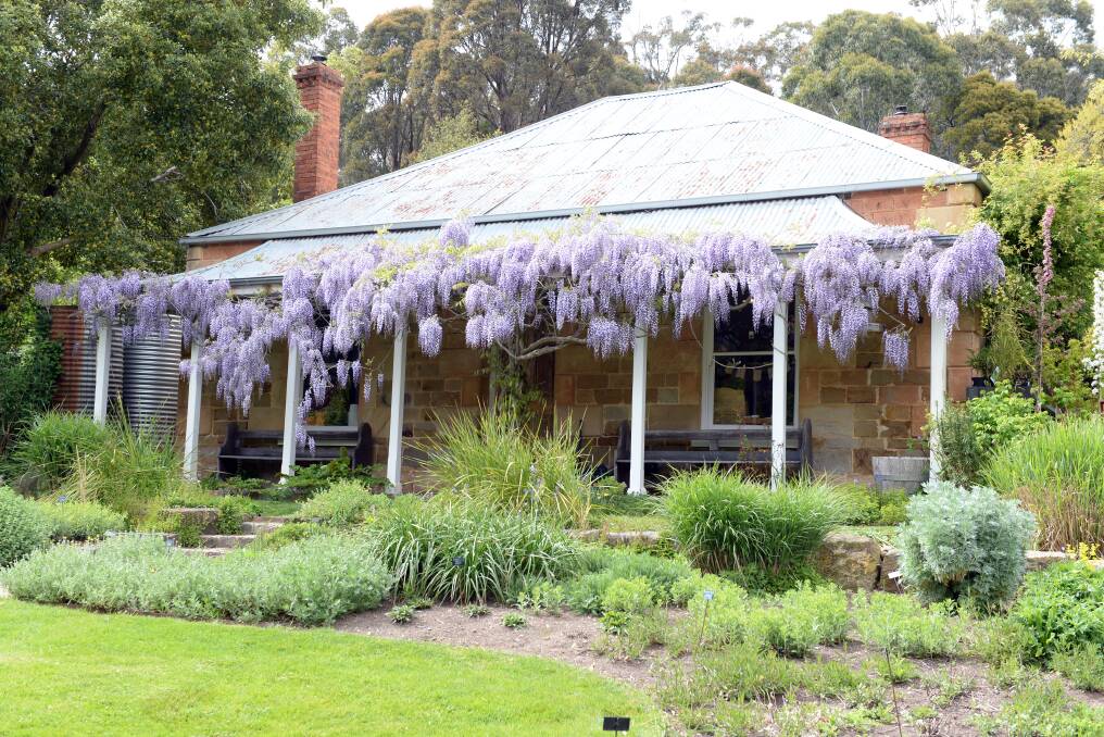 COTTAGE: The historic sandstone building, built circa 1860, is the centre of the garden. Photo: Kate Healy