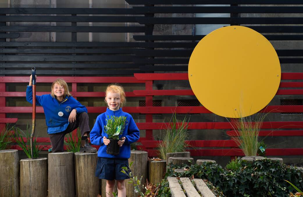 RECONCILIATION GARDEN: Nine-year-old Oscar Baker and 8-year-old Ruby Lohse planting Indigenous plants native to the region. Photo: Adam Trafford
