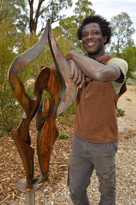LOVE AND DIVERSITY: Sculptor Issa Ouattara, with the piece he is donating to ChillOut Festival's Lavish Lunch to raise funds for the Daylesford SES. Photo: Dylan Burns