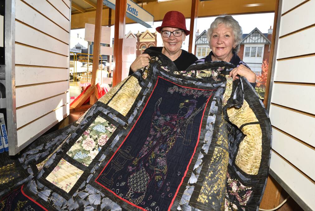 WHAT A BEAUTY: Carolyn Evans and Yvette Reading of the Spa Quilter's Guild of Daylesford with one of their large oriental themed quilts. Photo: Dylan Burns