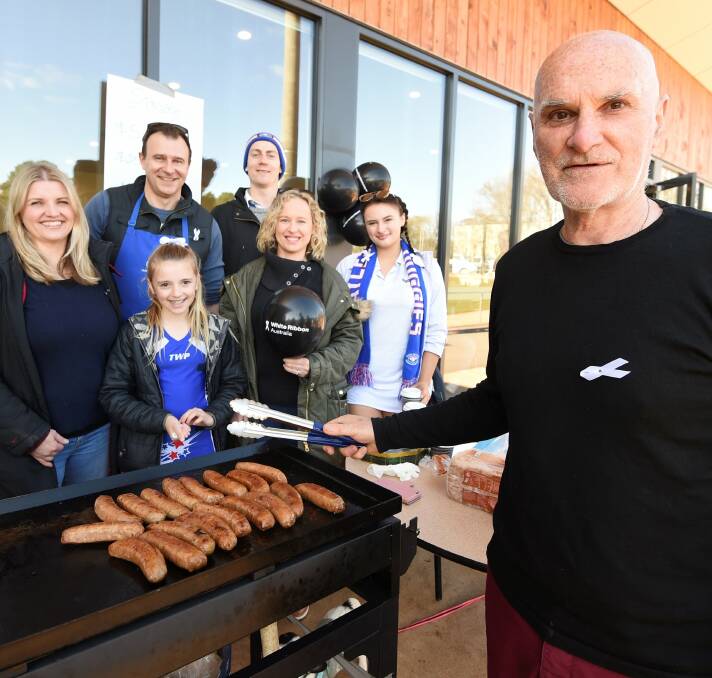 FUNDRAISER: Daylesford Football Netball Club supporters Annissa White, Club secretary Carson White, Zac Tisdale, Lillian White, 10, Belinda Buck, Briana Buck and Jeff Stewart all helped with the sausage sizzle on Saturday. Photo: Lachlan Bence