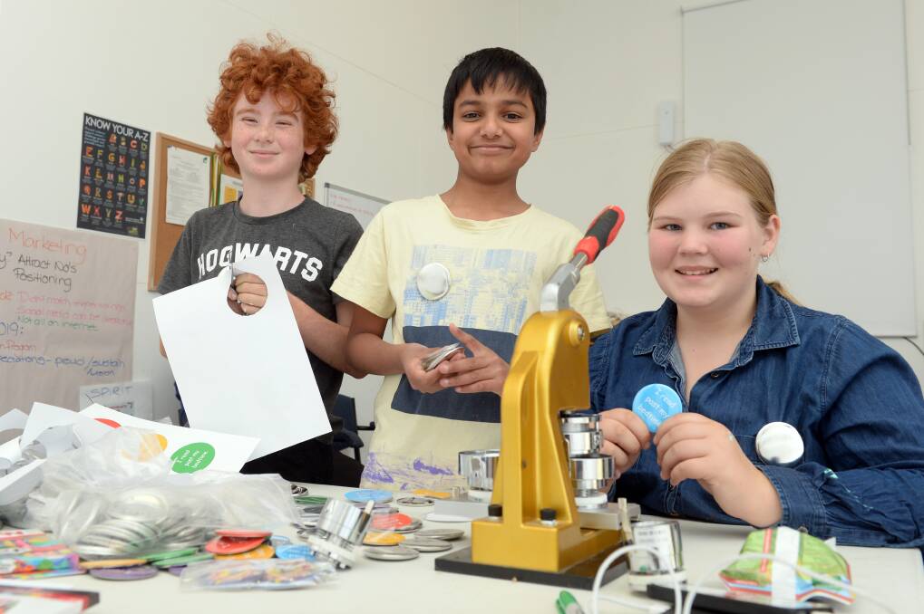 YOUNG ENTREPRENEURS: Clunes youngsters James de Kort, 10, Purv Patel, 10,  and Hannah Farren, 12, make badges to include in the showbags. Photo: Kate Healy