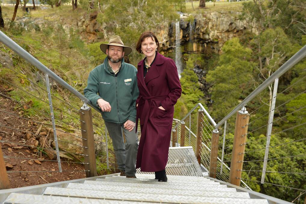 WATERFALL: Parks Victoria district manager Tony English and Macedon MP Mary-Anne Thomas take the first steps on the new staircase at its reopening in August 2017. Picture: Dylan Burns