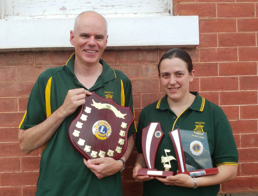TROPHY PROUD: Roger Clark and Katrina Bird pose with the Creswick Brass Band's winning trophies. 