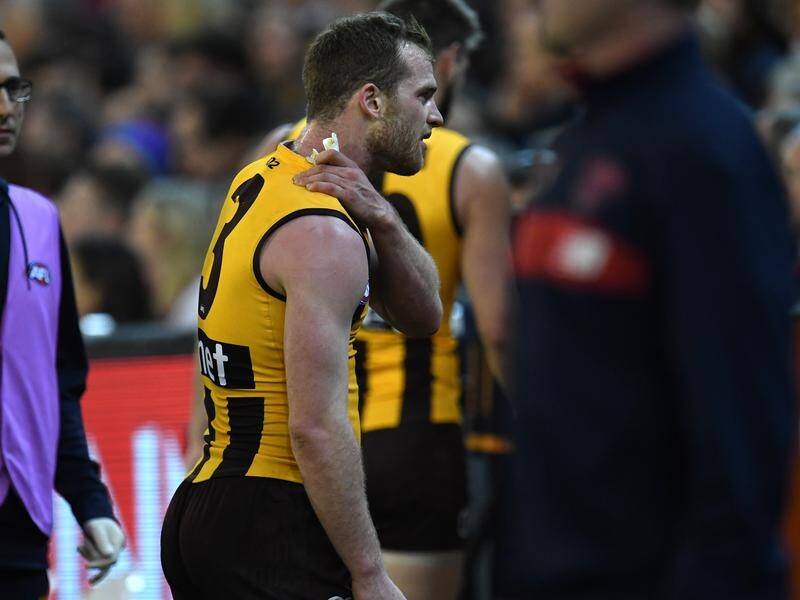 Hawks midfielder Tom Mitchell leaves the field in pain against the Dees after a Neville Jetta bump.
