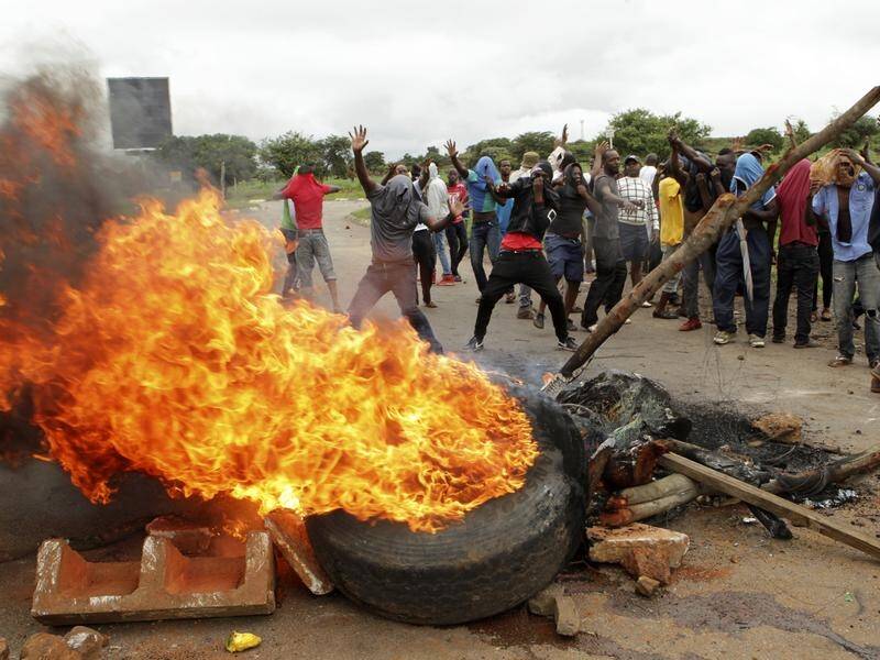 Protestors gather near a burning tyre during a demonstration over high fuel prices in Zimbabwe.