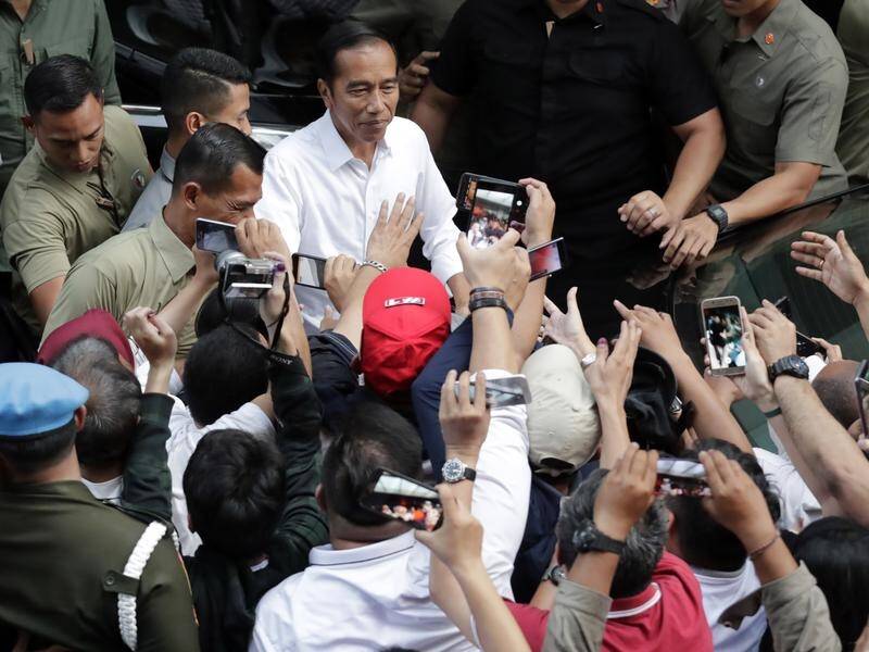 Early results say Joko Widodo (C) leads in Indonesia's presidential polls but his rival disputes it.