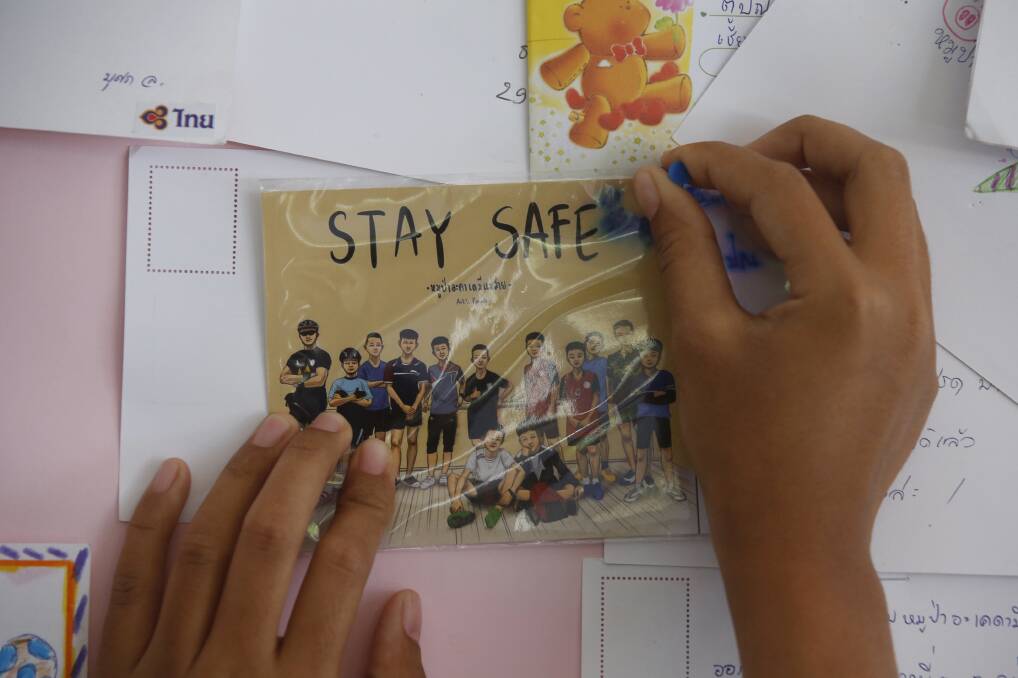 A Thai well wisher puts a poster to pray for boys and their soccer coach . Picture: AP