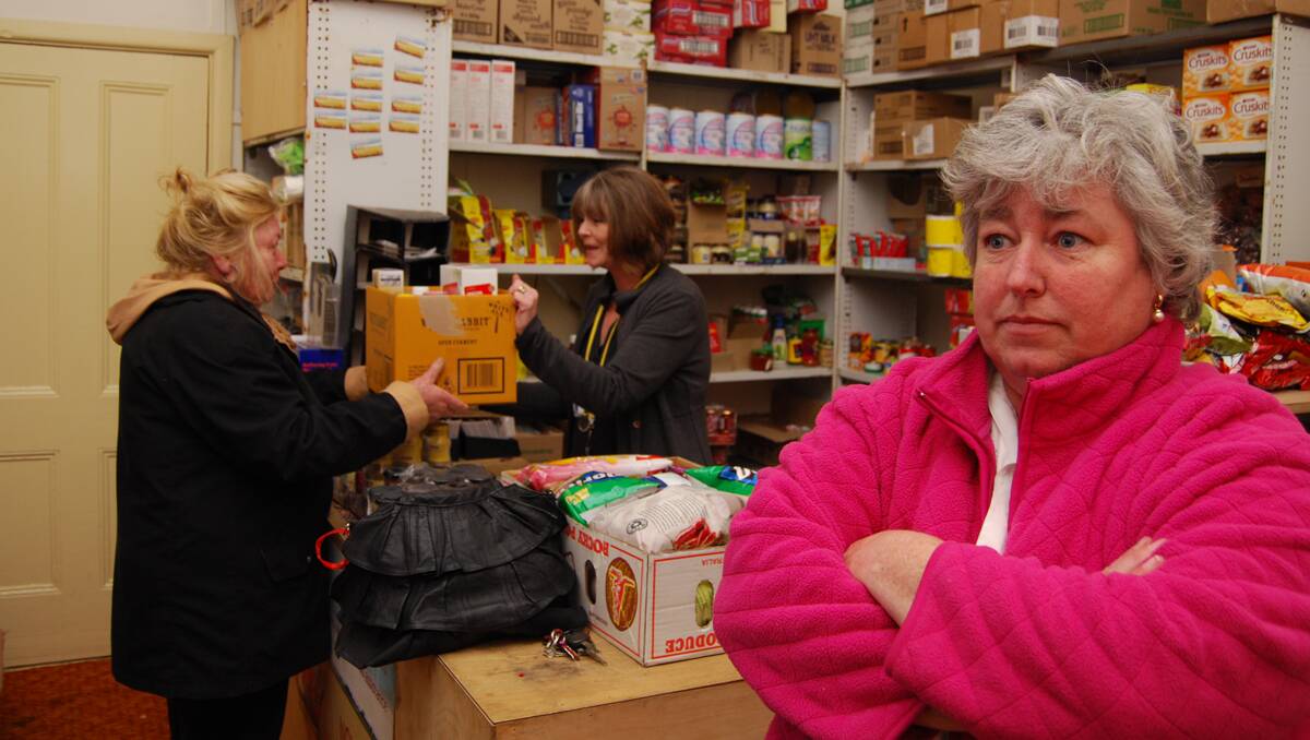 Left; Kathleen Trigger hands over a box of food to Colleen Shields from the Daylesford foodbank while foodbank coordinator Carmel Thannhauser surveys the burglary damage.